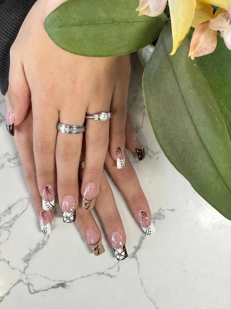 Neutral french tip nails with white floral and line-art details
