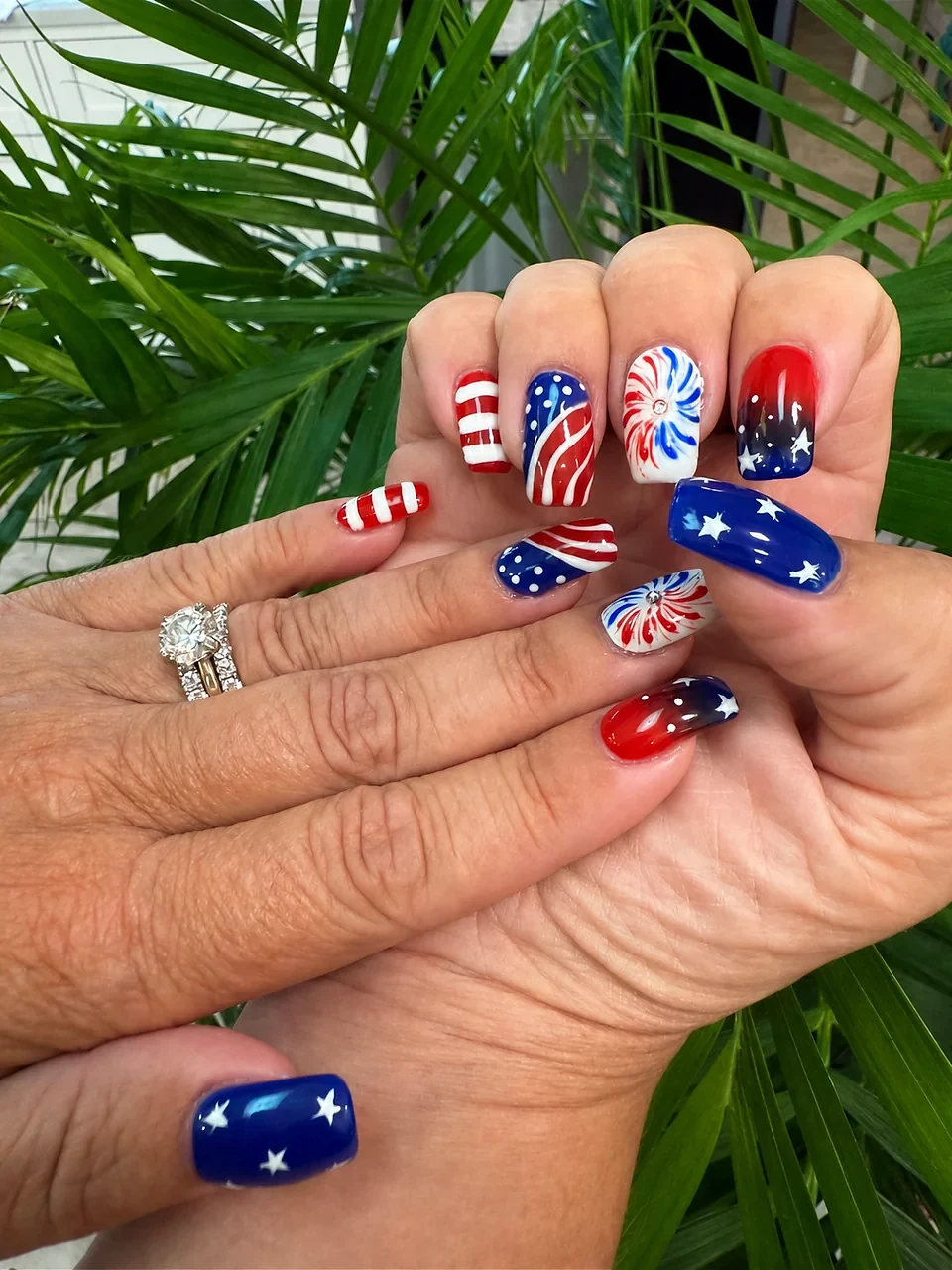 Red, white, and blue nails with stars, stripes, and firework designs